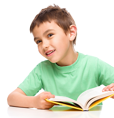 Image showing Little boy plays with book