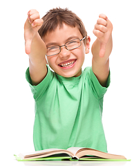 Image showing Little boy is reading a book