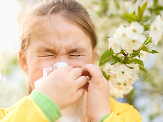 Image showing Little girl is blowing her nose