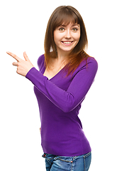 Image showing Portrait of a young woman pointing to the left