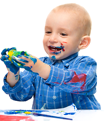 Image showing Little boy is playing with paints