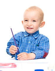 Image showing Little boy is playing with paints