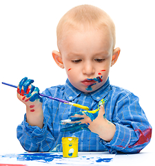 Image showing Little boy is playing with paints