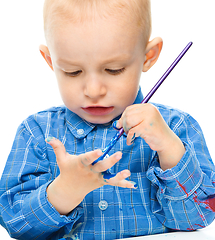 Image showing Little boy is playing with paints