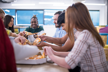 Image showing multiethnic business team eating pizza