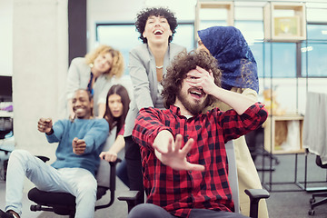 Image showing multiethnics business team racing on office chairs