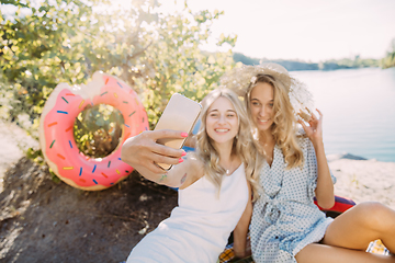 Image showing Young lesbian\'s couple having fun and spending time at riverside in sunny day