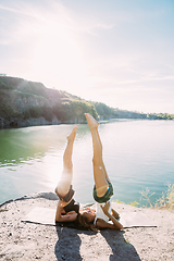 Image showing Young lesbian\'s couple exercizing yoga at riverside in sunny day