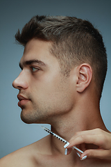 Image showing Close-up portrait of young man isolated on grey studio background