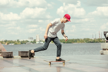 Image showing Skateboarder doing a trick at the city\'s street in sunny day