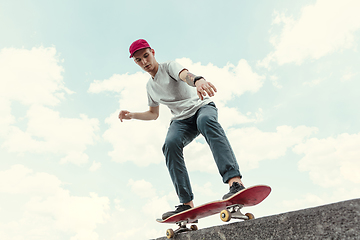 Image showing Skateboarder doing a trick at the city\'s street in sunny day