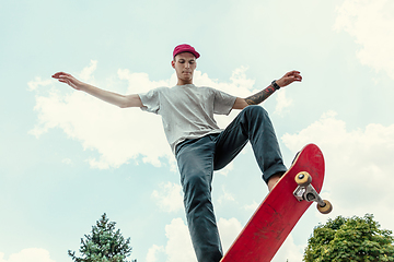 Image showing Skateboarder doing a trick at the city\'s street in sunny day