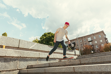 Image showing Skateboarder doing a trick at the city\'s street in sunny day