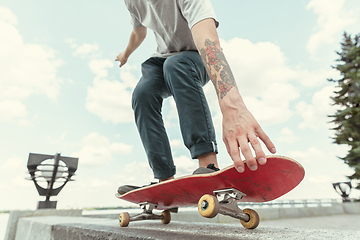 Image showing Skateboarder doing a trick at the city\'s street in sunny day