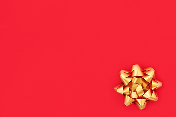 Image showing Christmas Gold Ribbon Bow on Red Wrapping Paper