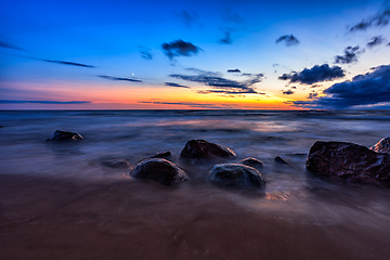 Image showing Sea sunset seascape with wet rocks