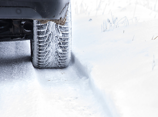 Image showing Winter Tyre on snowy country road.