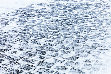 Image showing Cobblestone pavement covered with snow and ice
