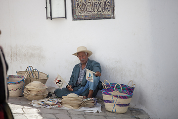 Image showing Elder street vendor selling handmade souvenirs 