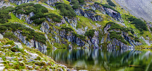 Image showing Mountain slope with small lake at botom