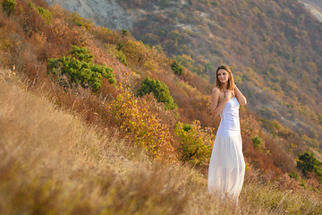 Image showing Beautiful slender girl in white clothes on the background of a beautiful mountain landscape