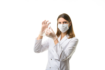 Image showing Girl doctor stands with a glass test tube in her hands