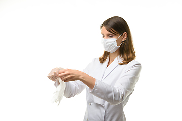 Image showing Girl doctor unfolds medical gloves before putting them on