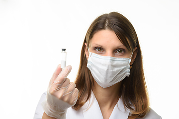 Image showing Girl doctor holding a glass tube with white powder in her hands