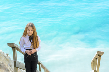 Image showing Portrait of a beautiful girl ten years old, in the background a blue-white sea