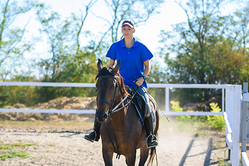 Image showing Girl practicing horse riding on a warm summer day