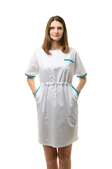 Image showing Girl in a white medical coat, hands in pockets, isolated on a white background