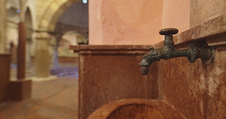 Image showing Old stone wash basin with decorative tap with water flowing