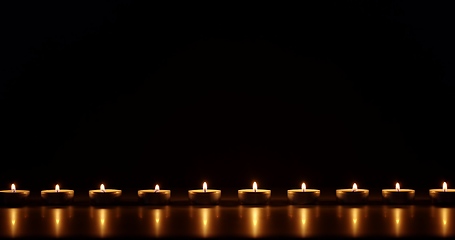 Image showing Candles glowing against dark background