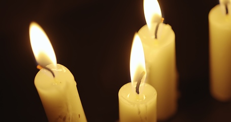 Image showing Candles glowing against dark background