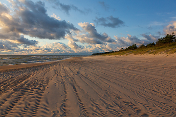 Image showing Wild sandy beach under cloudy sky of sunset