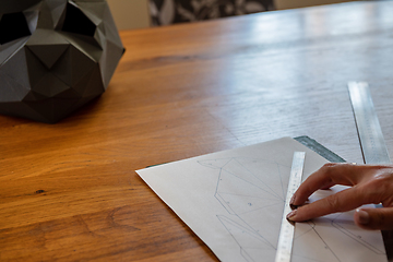 Image showing Somebody is making a cube sculpture with paper and linear