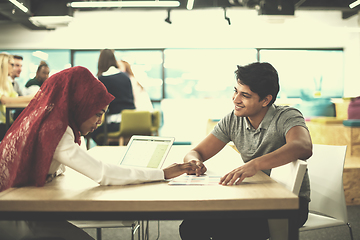 Image showing black muslim business woman having a meeting with her indian mal