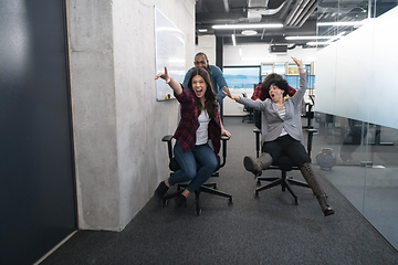 Image showing multiethnics business team racing on office chairs