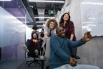 Image showing multiethnics business team racing on office chairs