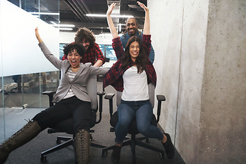 Image showing multiethnics business team racing on office chairs