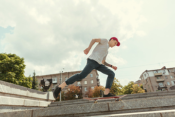 Image showing Skateboarder doing a trick at the city\'s street in sunny day