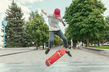 Image showing Skateboarder doing a trick at the city\'s street in sunny day
