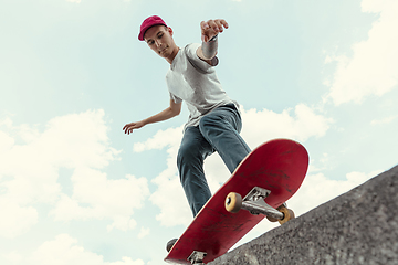 Image showing Skateboarder doing a trick at the city\'s street in sunny day