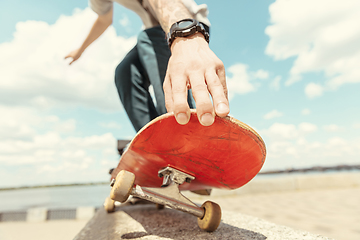 Image showing Skateboarder doing a trick at the city\'s street in sunny day