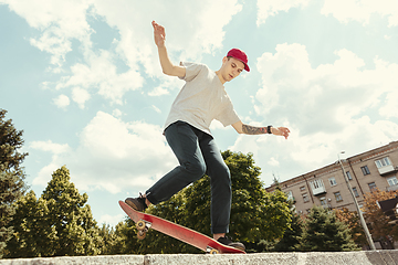 Image showing Skateboarder doing a trick at the city\'s street in sunny day