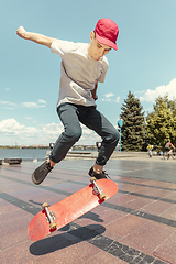 Image showing Skateboarder doing a trick at the city\'s street in sunny day