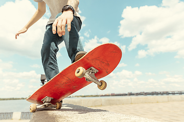 Image showing Skateboarder doing a trick at the city\'s street in sunny day