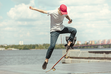 Image showing Skateboarder doing a trick at the city\'s street in sunny day