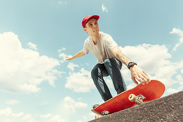 Image showing Skateboarder doing a trick at the city\'s street in sunny day