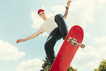 Image showing Skateboarder doing a trick at the city\'s street in sunny day